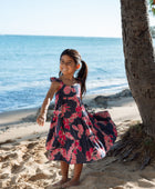 Girl in dress with dark navy ground and pink ginger and lei.