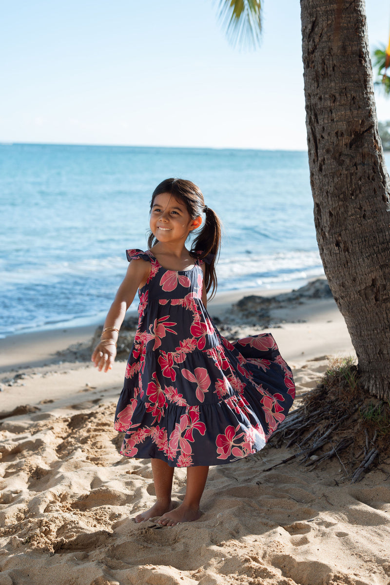 Girl in dress with dark navy ground and pink ginger and lei.