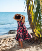 Girl in dress with dark navy ground and pink ginger and lei.