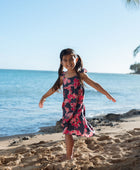 Girl in dress with dark navy ground and pink ginger and lei.