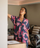 Woman in an above the knee shirt dress with dark navy ground and pink ginger and lei print.