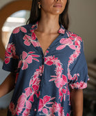 Woman in an above the knee shirt dress with dark navy ground and pink ginger and lei print.