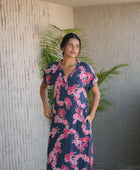 Woman in a long shirt dress with dark navy ground and pink ginger and lei print.