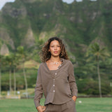 Woman wearing loose button up, smocked tube top and short in medium brown linen.