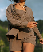 Woman wearing loose button up, smocked tube top and short in medium brown linen.