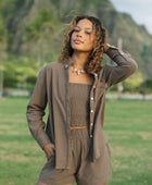 Woman wearing loose button up, smocked tube top and short in medium brown linen.