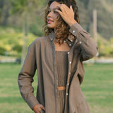 Woman wearing loose button up, smocked tube top and short in medium brown linen.
