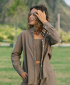 Woman wearing loose button up, smocked tube top and short in medium brown linen.