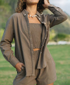 Woman wearing loose button up, smocked tube top and short in medium brown linen.