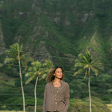 Woman wearing loose button up, smocked tube top and short in medium brown linen.