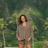 Woman wearing loose button up, smocked tube top and short in medium brown linen.