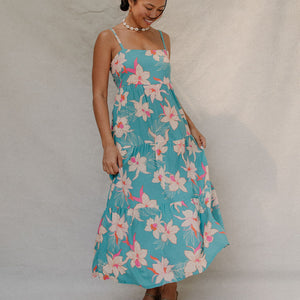 woman with brown hair wearing maxi tie back dress in teal with orchid pattern