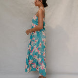 woman with brown hair wearing maxi tie back dress in teal with orchid pattern