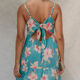 woman with brown hair wearing maxi tie back dress in teal with orchid pattern