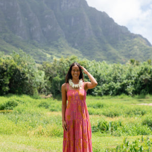 woman wearing a pink tie back maxi dress with lei print