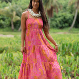 woman wearing a pink tie back maxi dress with lei print