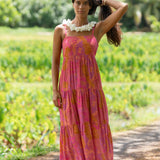 woman wearing a pink tie back maxi dress with lei print