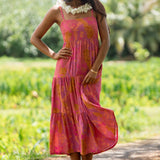 woman wearing a pink tie back maxi dress with lei print