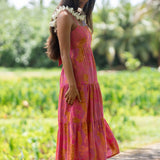 woman wearing a pink tie back maxi dress with lei print