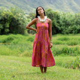 woman wearing a pink tie back maxi dress with lei print
