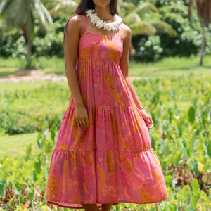 woman wearing a pink tie back maxi dress with lei print