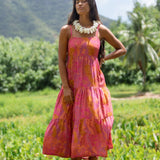 woman wearing a pink tie back maxi dress with lei print
