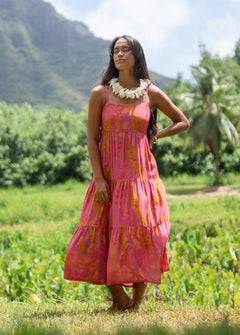 woman wearing a pink tie back maxi dress with lei print