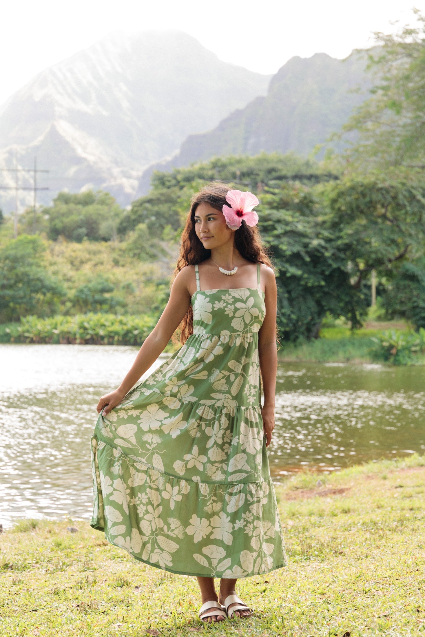 woman with brown hair wearing green tie back dress with native hawaiian plants