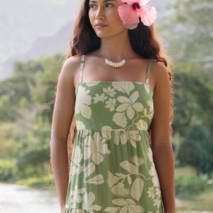 woman with brown hair wearing green tie back dress with native hawaiian plants