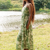 woman with brown hair wearing green tie back dress with native hawaiian plants