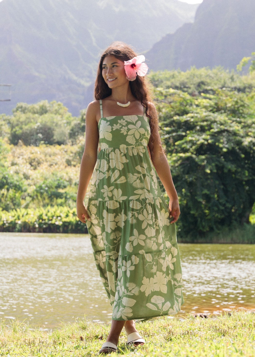 woman with brown hair wearing green tie back dress with native hawaiian plants