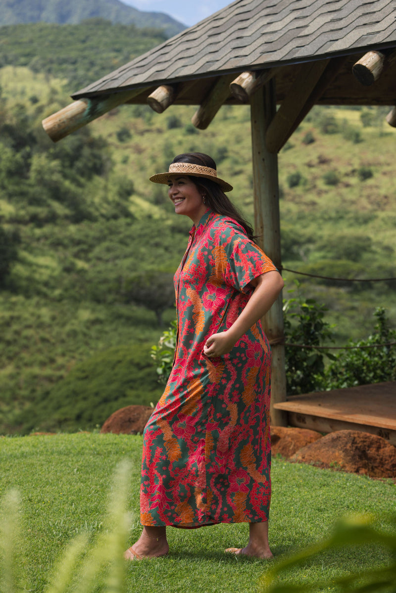 woman with brown hair wearing a colorful maxi button up dress with tropical lei print