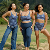 woman wearing a matching sports bra and pocket shorts workout set with blue hibiscus pattern