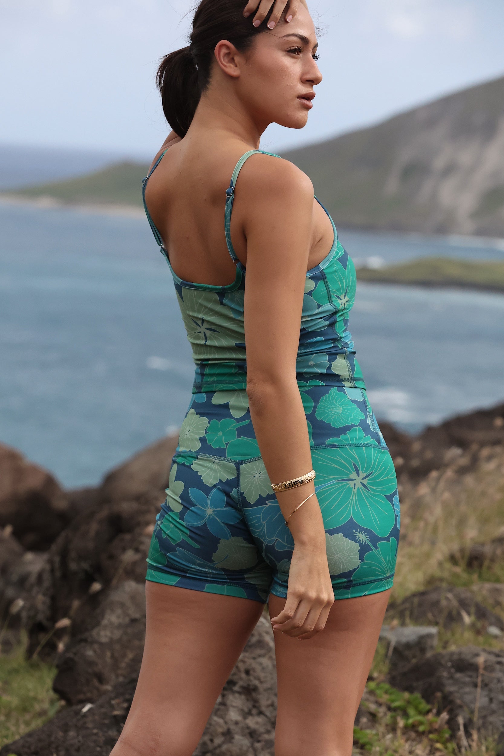 woman wearing matching activewear tank top and shorts in dark blue floral print