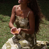 woman with brown hair wearing yellow glass plumeria necklace and earrings 