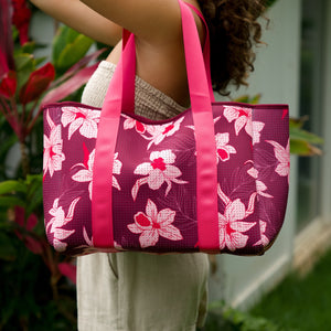 woman carrying wine colored neoprene tote bag with thick straps and detachable pouch with orchid print