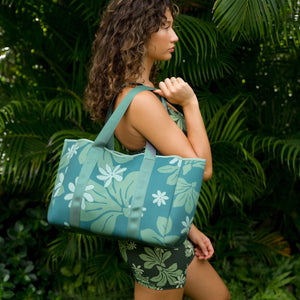 woman carrying canopy green colored neoprene tote bag with thick straps and detachable pouch with naupaka print