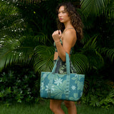 woman carrying canopy green colored neoprene tote bag with thick straps and detachable pouch with naupaka print