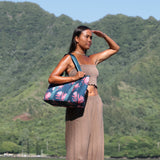 woman carrying a rich teal neoprene tote with blush colored protea print