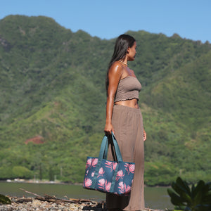 woman carrying a rich teal neoprene tote with blush colored protea print
