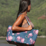 woman carrying a rich teal neoprene tote with blush colored protea print