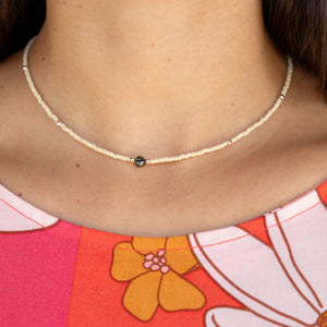 woman wearing a beaded keshi pearl necklace in sand color