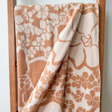 tan/nude woven cotton blanket featuring puakenikeni print