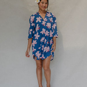 Woman with brown hair wearing mid sleeve button up dress in navy and hibiscus print