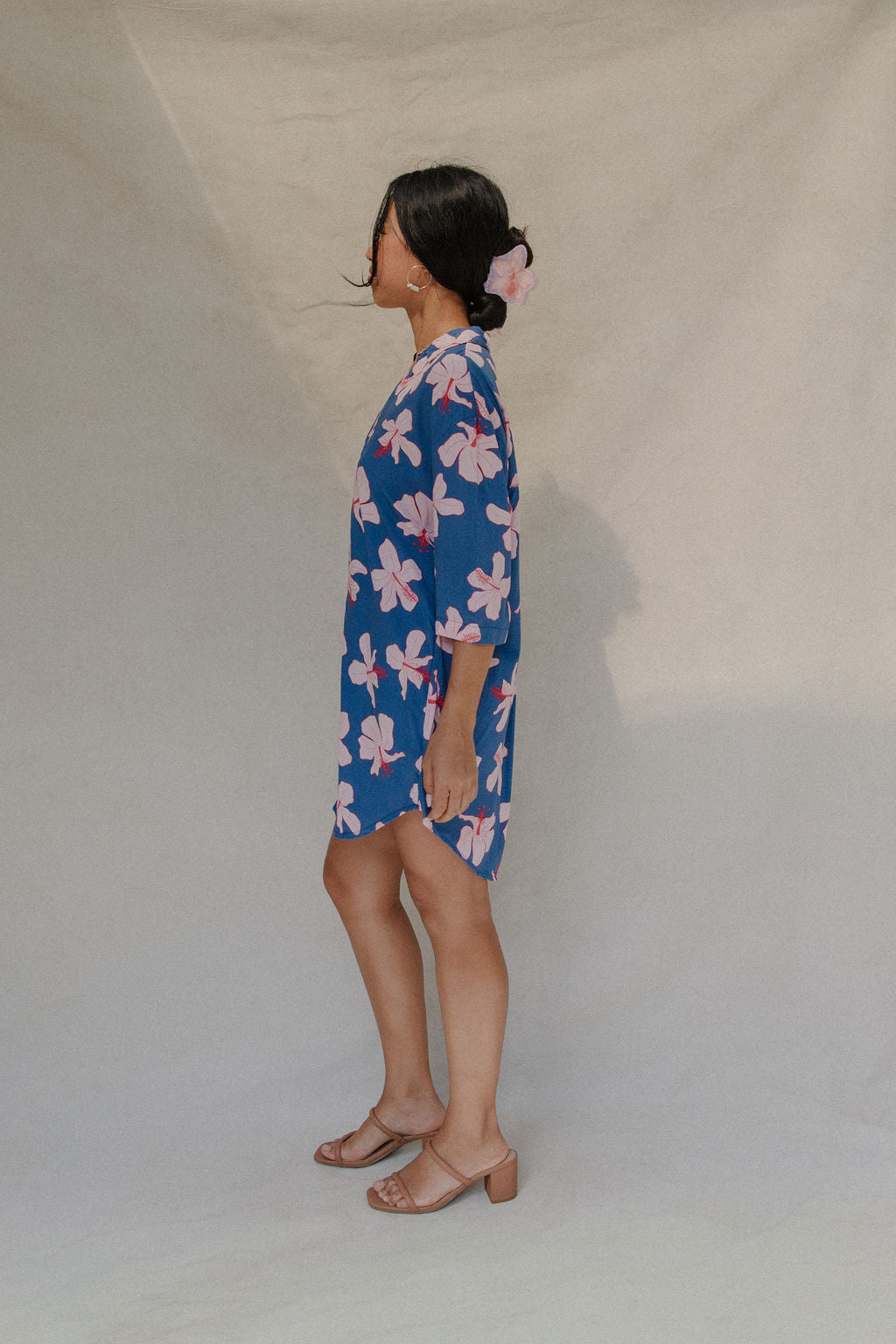 Woman with brown hair wearing mid sleeve button up dress in navy and hibiscus print