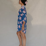 Woman with brown hair wearing mid sleeve button up dress in navy and hibiscus print