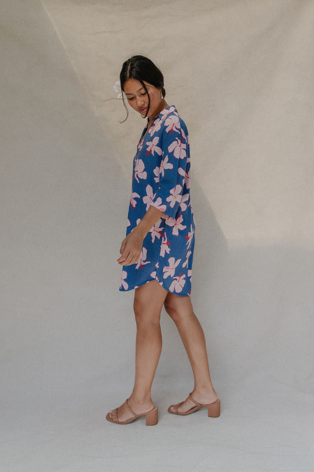 Woman with brown hair wearing mid sleeve button up dress in navy and hibiscus print