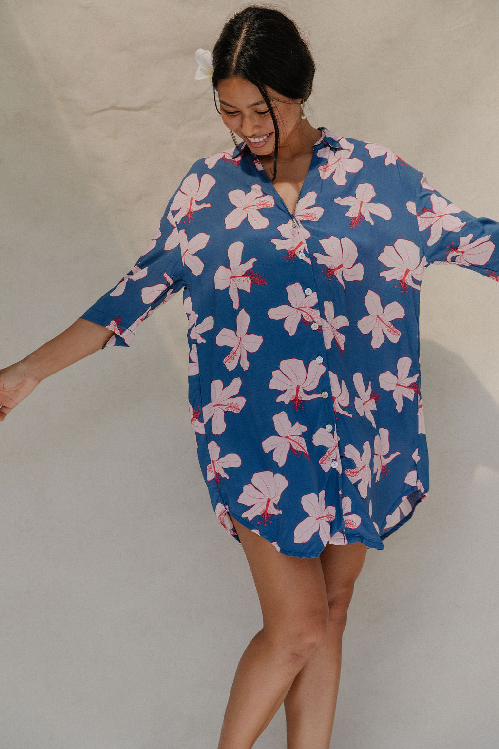 Woman with brown hair wearing mid sleeve button up dress in navy and hibiscus print
