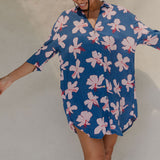 Woman with brown hair wearing mid sleeve button up dress in navy and hibiscus print