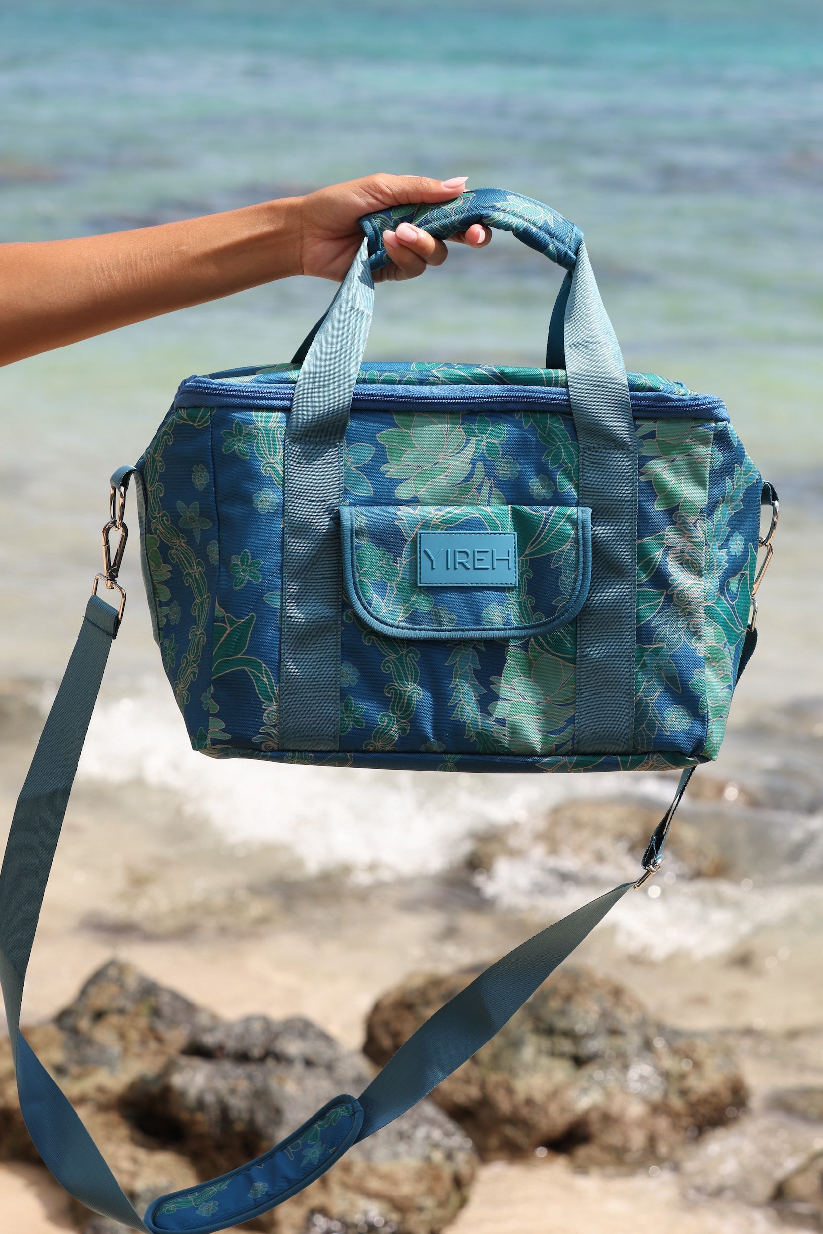 large cooler bag in blue green color with lei pattern featuring straps and handle